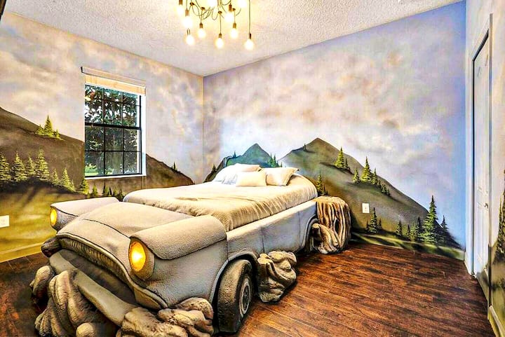 Cloud murals floor to ceiling — and a life-sized Ford Anglia hovering right in the middle of it. Working headlights, real radio. Mind the Whomping Willow. The kids will fight over this one.