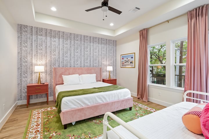 在华丽的主卧套房享受舒适的加大双人床，包括阳台通道、带步入式淋浴的套房卫生间、平板智能电视和步入式衣柜。    