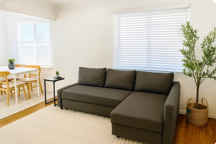 Dnevni boravak u prednjem dijelu. Dostupan je 75-inčni TV s Rokuom.