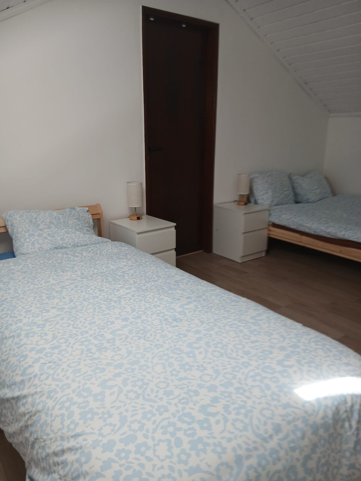 Deze kamer heeft een tweepersoonsbed en een eenpersoonsbed, voor een capaciteit van 1 tot 3 personen. Elk bed heeft een groot dressoir voor het opbergen van kleding en een nachtkastje met een slimme lamp met een ingebouwde USB-oplader.