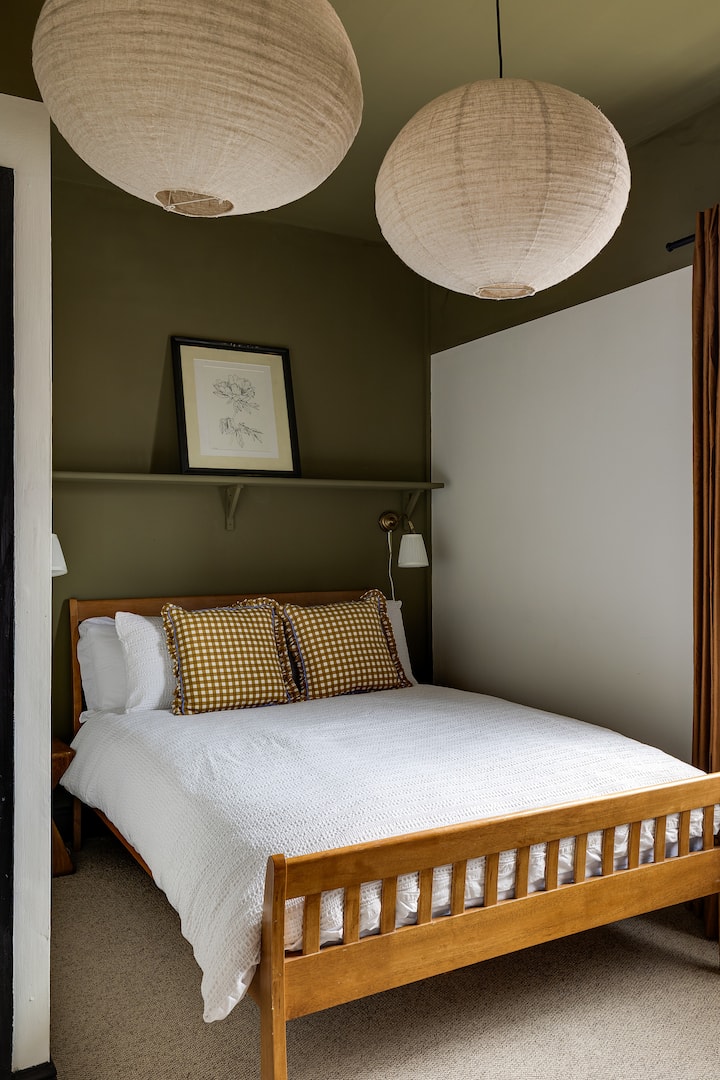 A calm, stylish bedroom with soft earthy tones, paper lantern lighting and a comfortable double bed. Designed for restful nights, this Emberkey Stays Chester room offers a cosy retreat for couples, solo guests or contractors on longer stays.