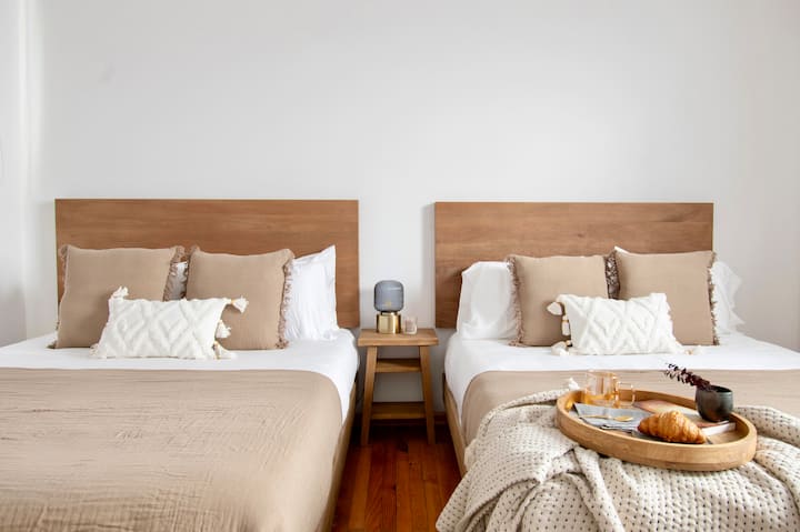 Რბილ ნეიტრალებში გამოწყობილი ტყუპი საწოლები ამ ჰაეროვან საძინებელში სიმეტრიითა და სიმშვიდით გამოირჩევა. Ბუნებრივი სინათლე, თბილი ხე და კარგად მოფიქრებული დეტალები ქმნის მიმზიდველ საცხოვრებელს, რომელიც იდეალურია დასვენებისა და ურთიერთობისთვის.