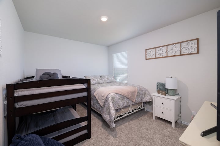 Este dormitorio cuenta con una cama de tamaño completo, dos literas individuales y un televisor inteligente. En el armario se puede guardar cómodamente un corralito plegable, por lo que es un espacio ideal para las familias.