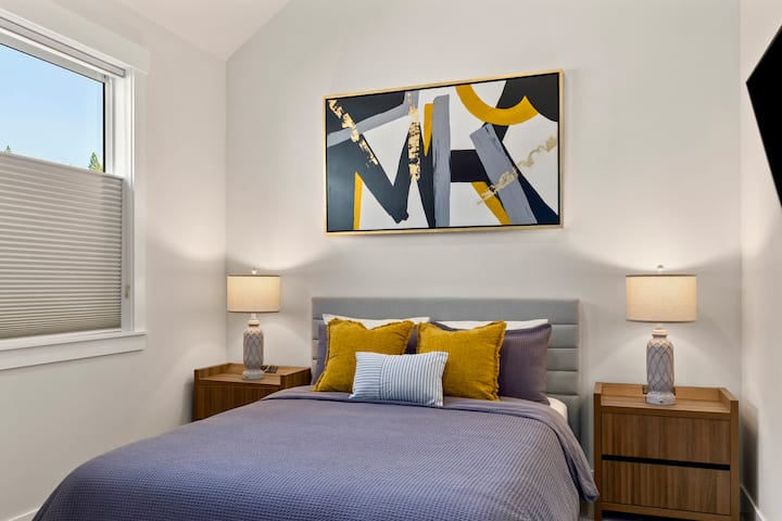 El segundo dormitorio ofrece un acogedor refugio con ropa de cama lujosa, tonos cálidos y una iluminación suave.