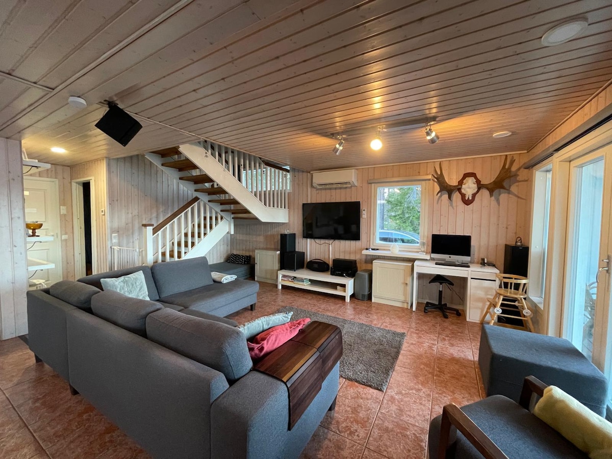 Всекидневната се намира на първия етаж на къщата. 

Под стълбите, които се изкачват нагоре, има единично легло с размери 90 х 200 см, а ъгловият диван може да се използва и за спане, ако е необходимо. В тази стая се намират и малко бюро и стол.

