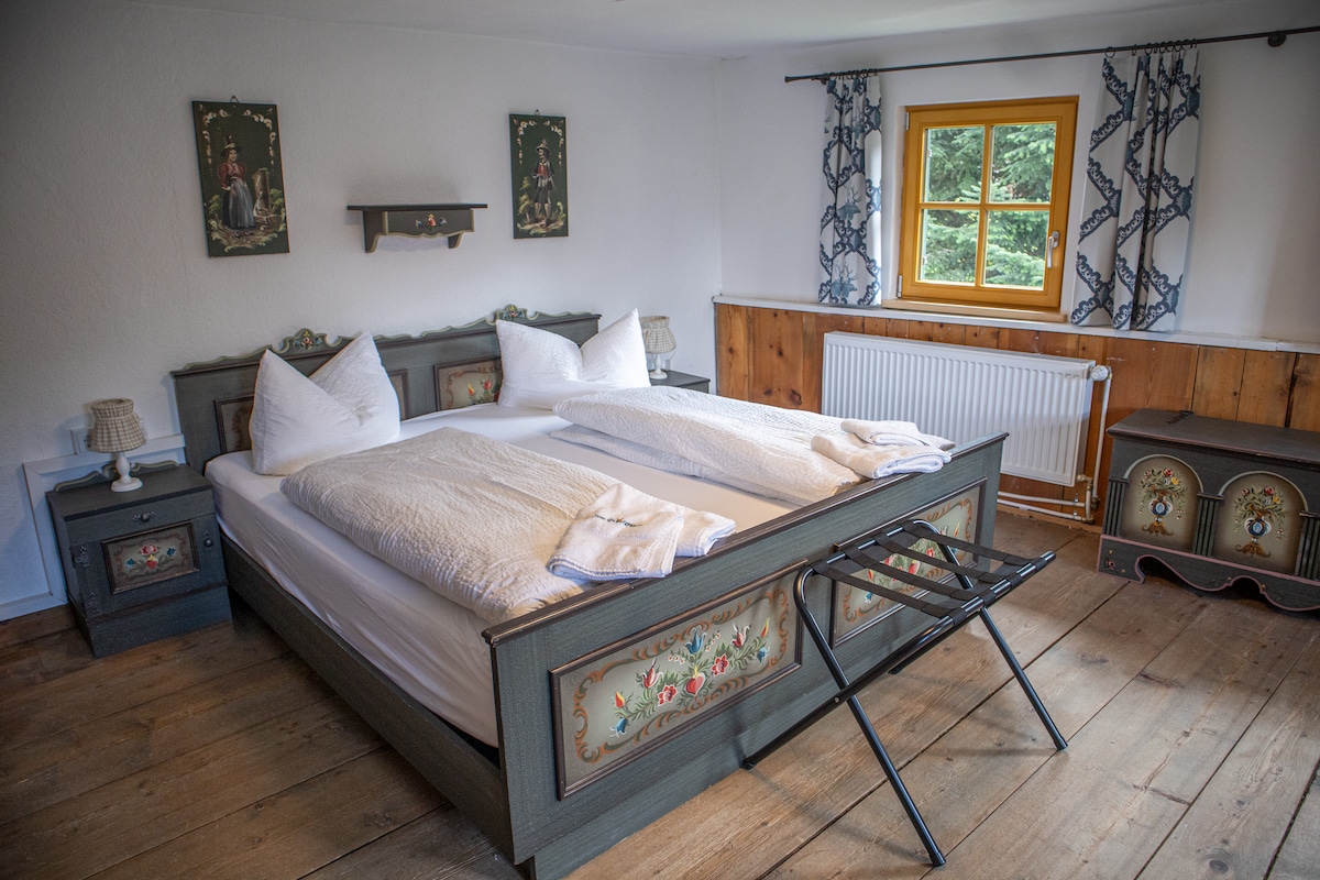 Amplia habitación con cama doble, cama individual y vistas a la montaña. Decoración tradicional, vestidor y pequeño espacio de trabajo.