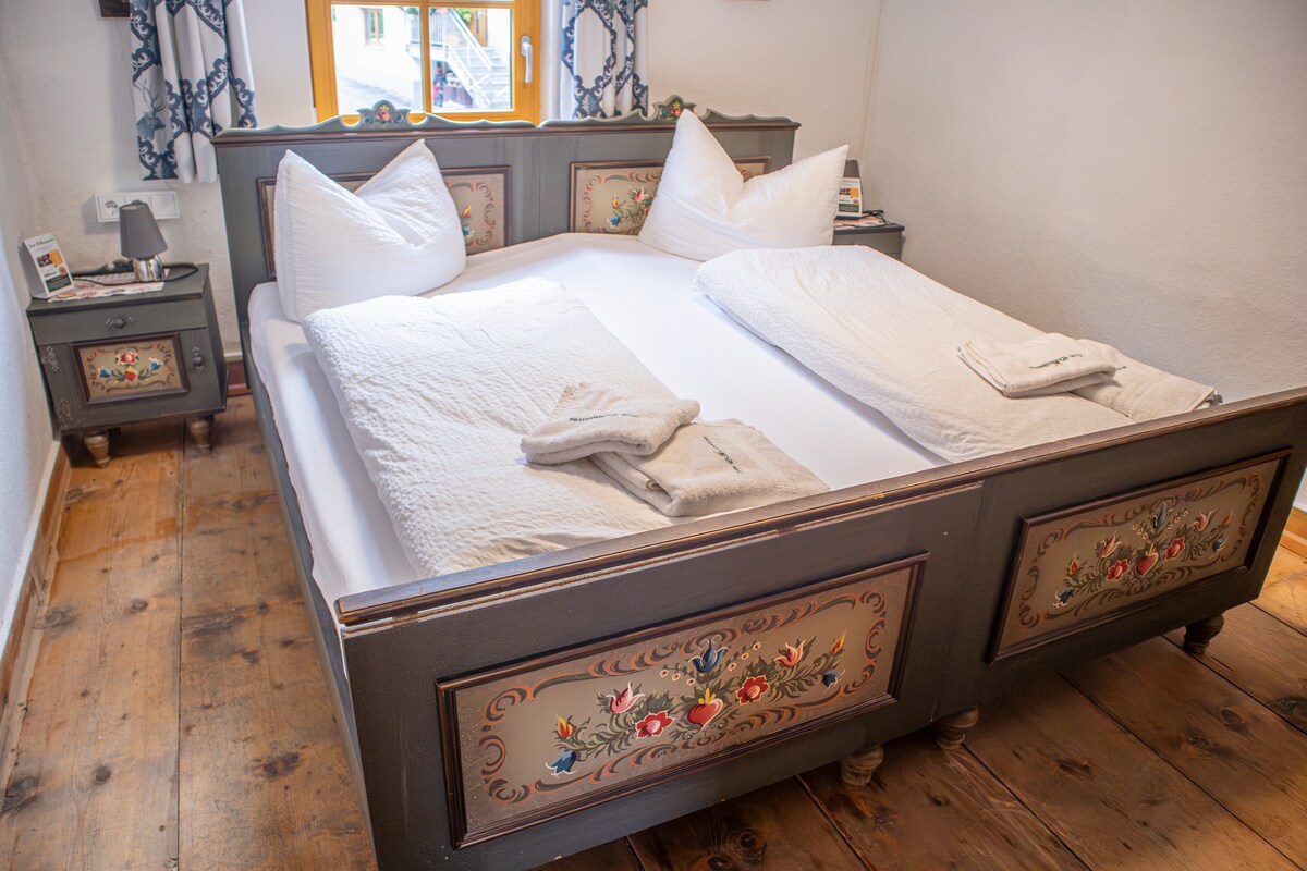 Acogedora habitación doble de estilo tradicional. Con armario y cálido estilo tirolés para sentirse bien.