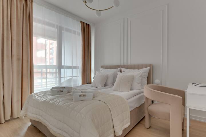 Un dormitorio luminoso y acogedor con una cama cómoda y cortinas opacas garantiza una comodidad completa. Un escritorio con un sillón crea un lugar cómodo para trabajar o estudiar.