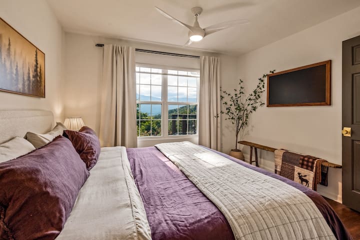 The master suite welcomes you with panoramic Smoky Mountain views framed by wide, light-filled windows.

