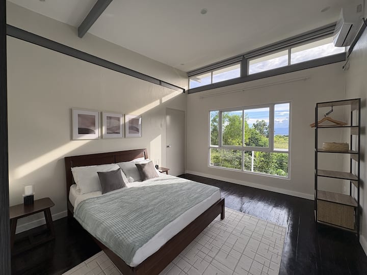 This serene bedroom combines minimalist design with tropical calm — a peaceful retreat featuring a plush queen bed, ensuite bathroom, and soothing garden views.