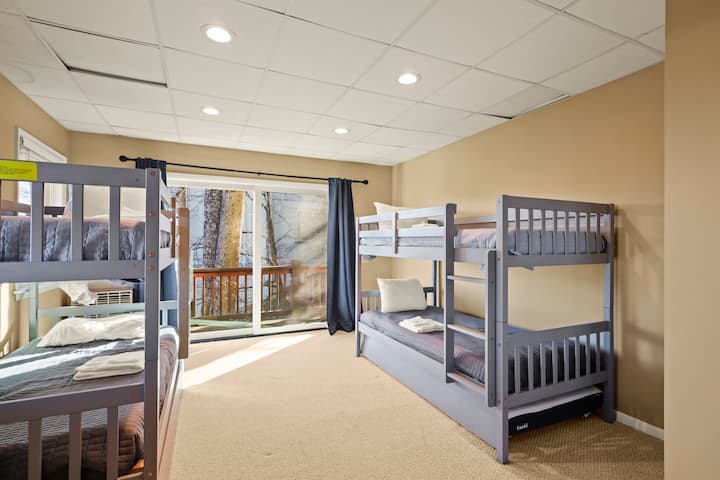 Táto izba s poschodovou posteľou je plná prirodzeného svetla, vďaka čomu je veselým priestorom pre deti a priateľov. Veľké okná a posuvné dvere udržujú vzdušnosť a viacero lôžok zabezpečuje, že každý má svoje vlastné pohodlné miesto na spanie.