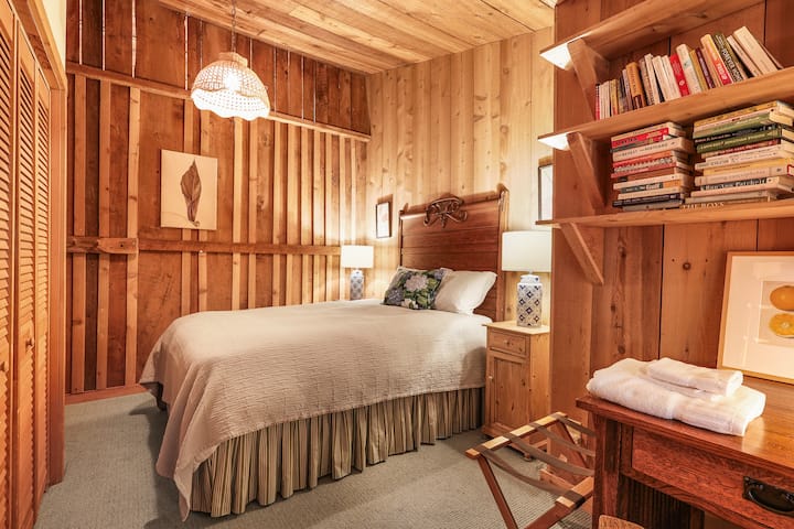 Cette chambre chaleureuse allie charme vintage et confort de cabane. Un éclairage doux, des murs en bois et des détails bien pensés créent un espace reposant, parfait pour se détendre après des aventures en montagne.