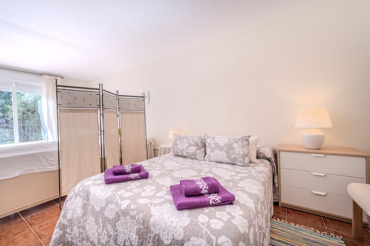 Dormitorio acogedor con cama de matrimonio, ropa de cama cuidada y ambiente tranquilo para un descanso de verdad.