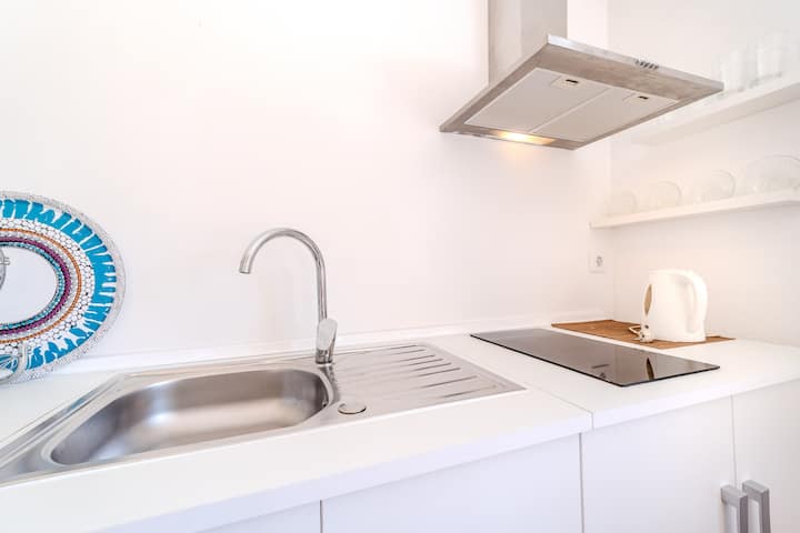 Cocina equipada con encimera amplia, vitrocerámica y todo lo necesario para cocinar como en casa.