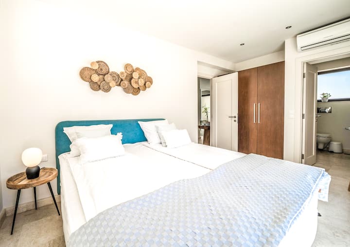 קומה תחתונה: חדר שינה 4 עם מיטת קינג סייז, חדר רחצה צמוד ומרפסת