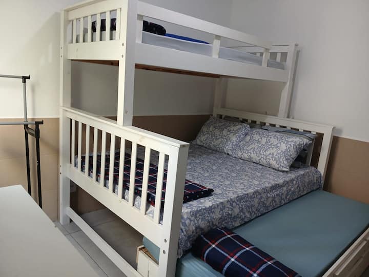Slaapkamer met een uitschuifbaar bed, twee eenpersoonsbedden en een tweepersoonsbed.