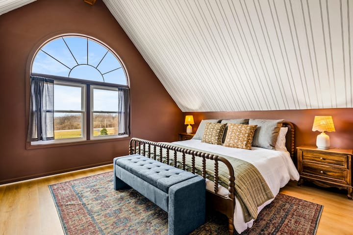 Architectural elegance meets total comfort: Wake up to sweeping views through our grand arched window, framed by a unique vaulted ceiling and warm, moody tones for the ultimate sanctuary stay. ✨