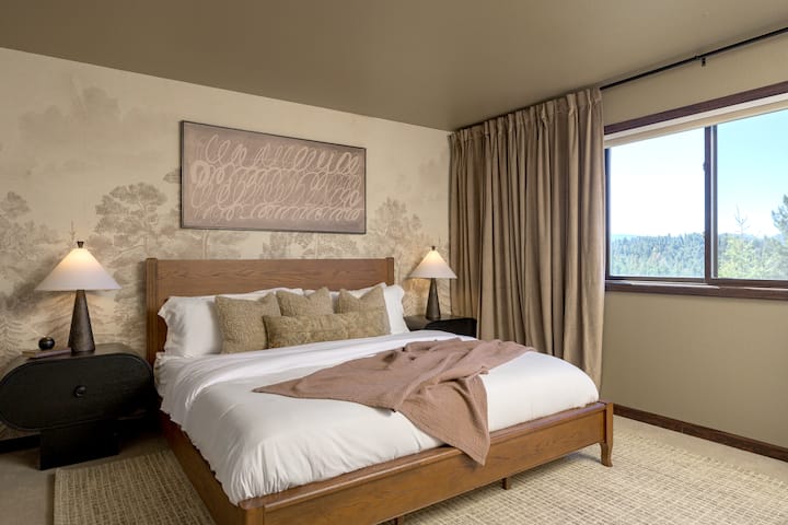 Camera da letto splendidamente progettata con letto king size, murale ad albero, splendida vista sulla foresta, angolo lavoro e ampio armadio.