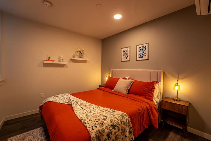 Relájate en un dormitorio cálido y acogedor, decorado con tonos intensos, sábanas suaves y un ambiente relajante.