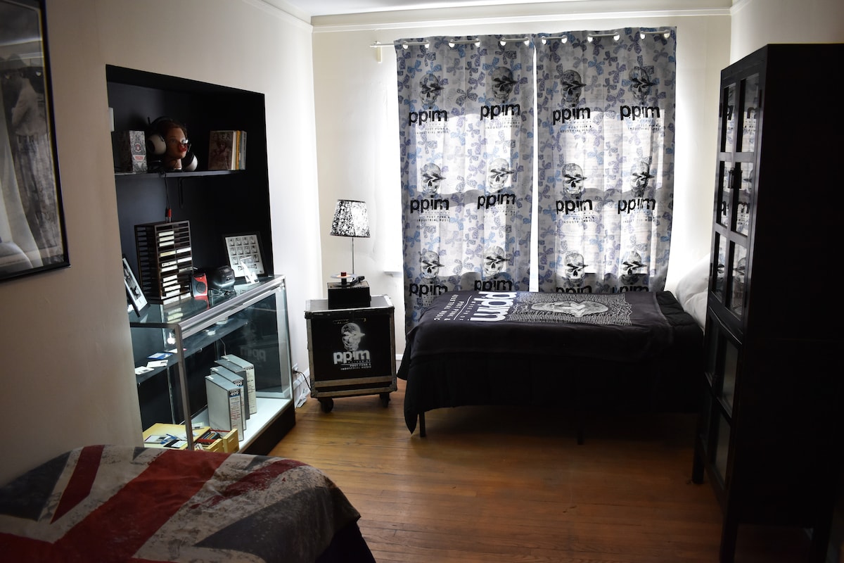 Second bedroom with curated archival displays and a calm, sleep-friendly layout.