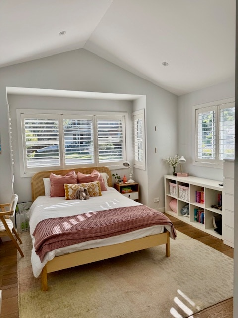 غرفة نوم مضاءة بسرير كوين والكثير من التخزين ومكتب الدراسة.