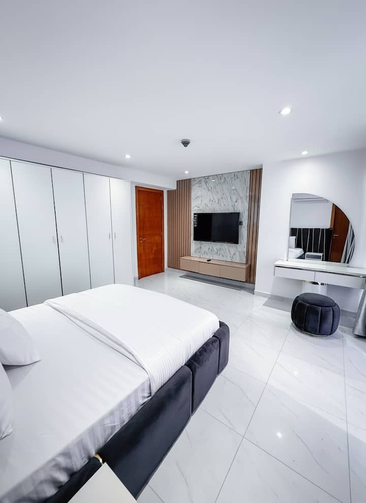 Elegantna spavaća soba s mramornim detaljima i modernim toaletnim stolom.