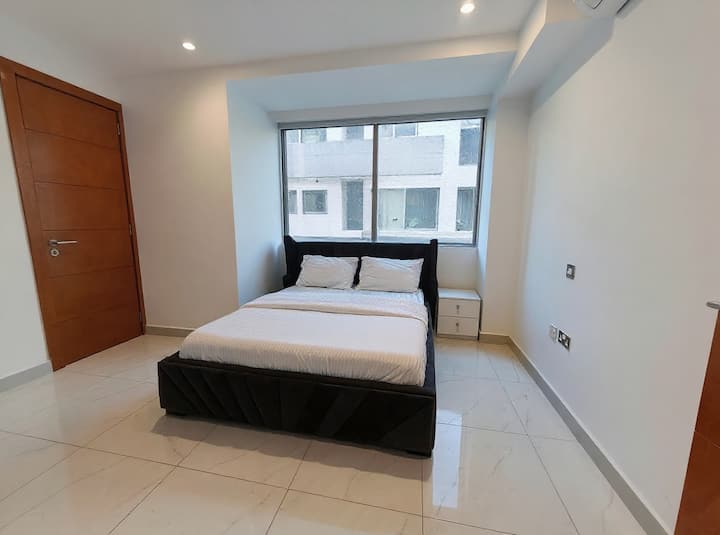 Elegantno urbano utočište s baršunastim krevetom, modernim mramornim podovima i velikim prozorima.