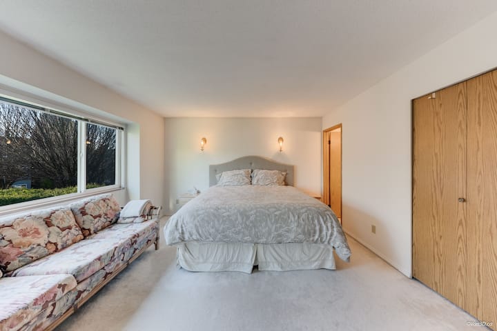 Prostrana glavna spavaća soba s velikim bračnim krevetom, dva noćna ormarića, udoban kauč, toaletni stol, garderoba i privatna kupaonica.