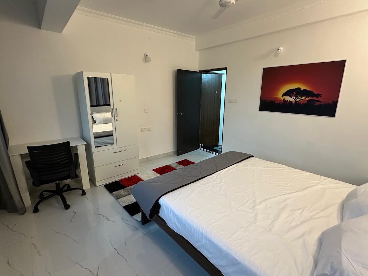 Hneď vojdete do izby a cítite pokoj. Biele steny, mäkké svetlo a umenie pri západe slnka mu dodávajú teplú, tichú energiu. Je to typ priestoru, kde si odložíte kufre, natiahnete sa a nakoniec necháte, aby sa deň spomalil.