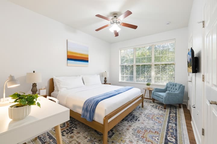 Este dormitorio tiene una cama tamaño king con una hermosa vista de los árboles detrás del edificio. Tiene un televisor HD de 32 pulgadas, un vestidor, un escritorio y un espejo de cuerpo entero. Tiene su propio baño completo adjunto con bañera/ducha.