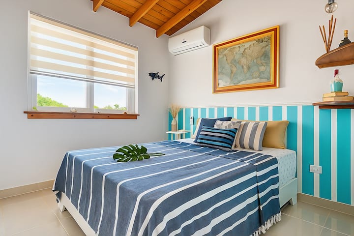 O segundo quarto tem uma cama queen size, ar-condicionado e vistas espetaculares para o mar para uma estadia confortável e relaxante.