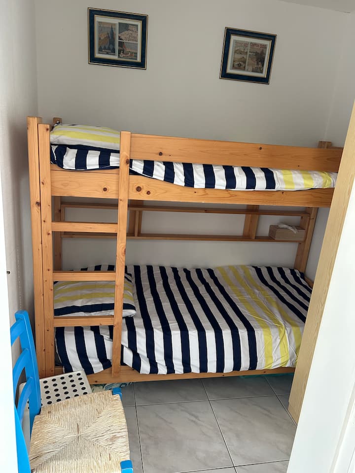 Small bedroom with two bunk beds and a wardrobe. 