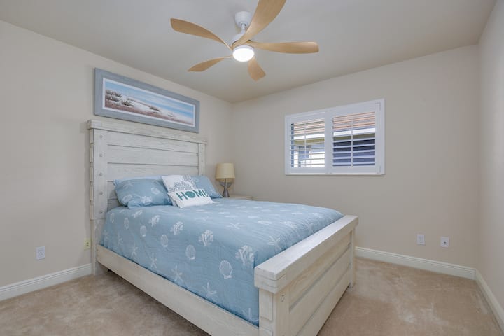 Hosťovská spálňa s nočným stolíkom, šatníkom, stropným ventilátorom s diaľkovým ovládaním a nástennou inteligentnou TV.