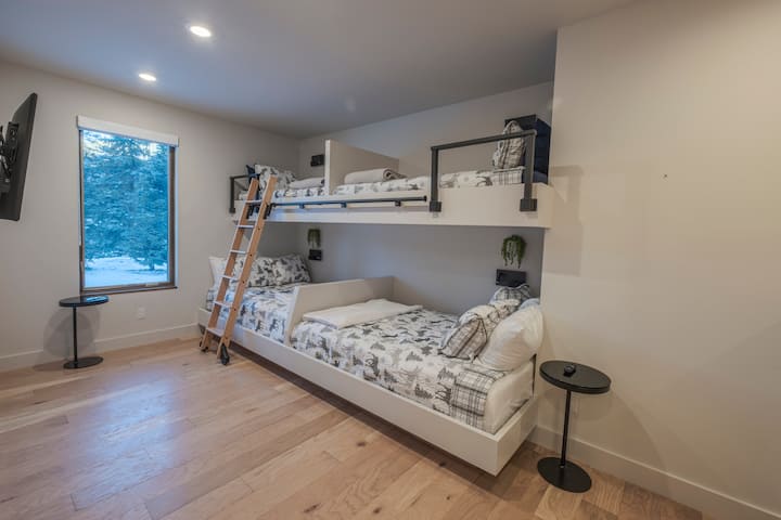 下层双层床房，配备两张全尺寸床和两张单人床以及套房卫生间