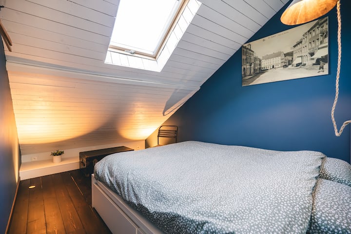 De lichte kamer heeft twee kapstokken, een stoel en decoratieve objecten die de authenticiteit van het huisje benadrukken.