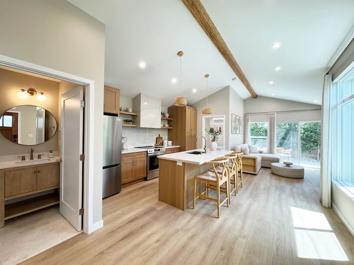 منطقة معيشة مفتوحة بأسقف مقببة طويلة ونوافذ كبيرة تملأ الغرفة بالضوء الطبيعي.