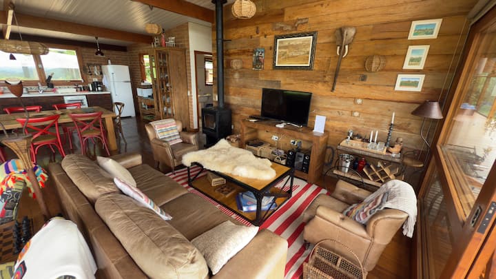 Sala confortável, com sofá e poltronas em couro e Smart TV