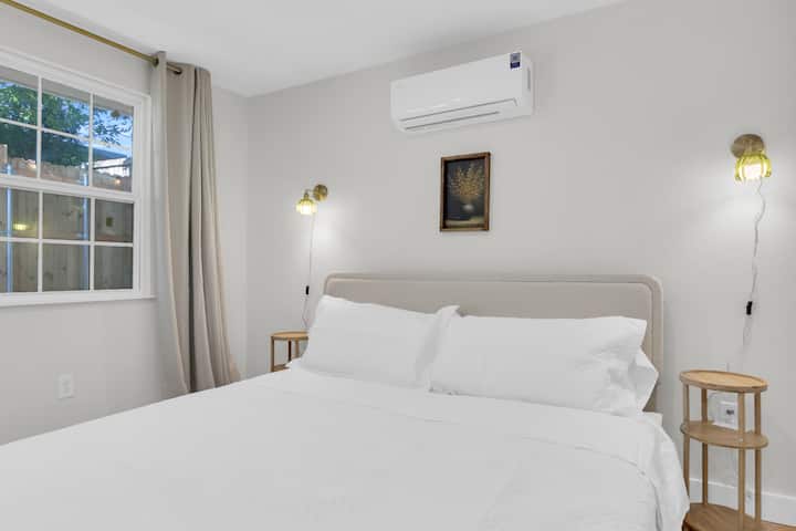 Starehe inakidhi mtindo na kitanda kikubwa chenye matakia, mapazia ya kufunika chumba, kiyoyozi, mwanga wa joto, na mwonekano kamili wa runinga kwa ajili ya usiku wa filamu.