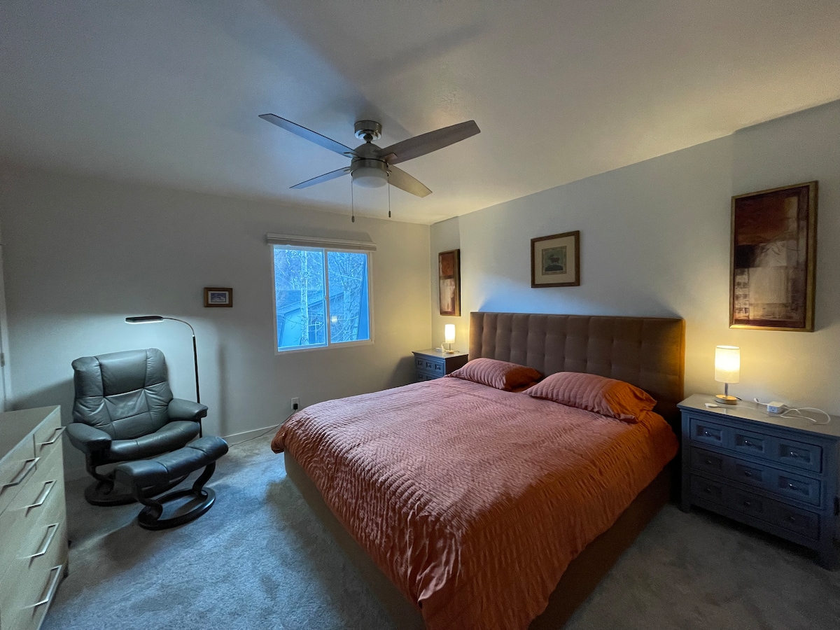 Amplio dormitorio principal en la planta superior con cama tamaño king, ventilador de techo y proporciones generosas que crean un refugio cómodo y privado.