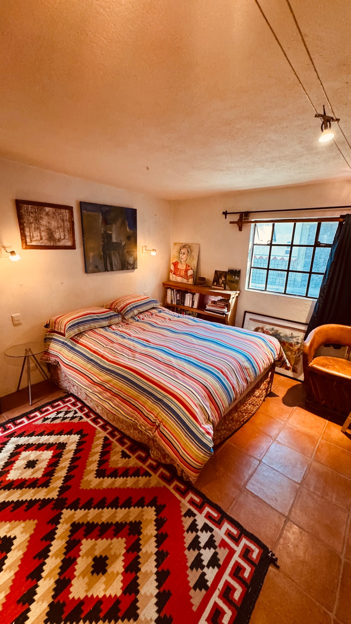 Chumba cha kulala cha ghorofa kuu kina nafasi ya kutosha ya kabati na bafu la ndani.