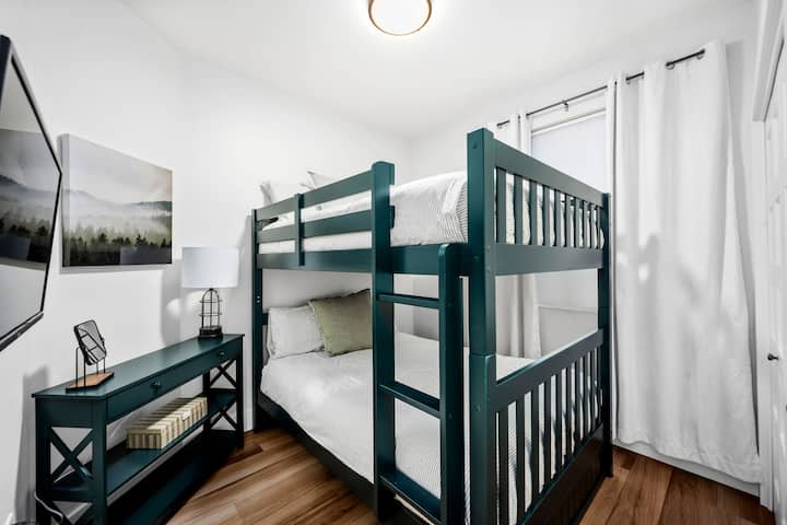 Dvojlôžkové poschodové postele s televízorom a šatníkom.