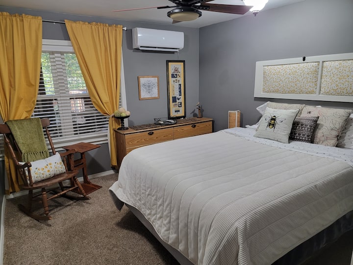 Downstairs birds and bees bedroom with queen bed and rocking chair
