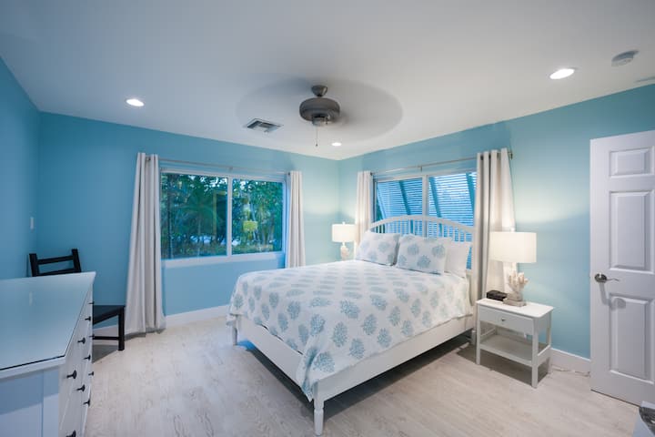 Dormitorio tamaño queen con vistas al jardín y cortinas opacas.  Baño compartido de gran tamaño junto al pasillo (ubicado en el popular ala este de la casa, perfecto para familias).