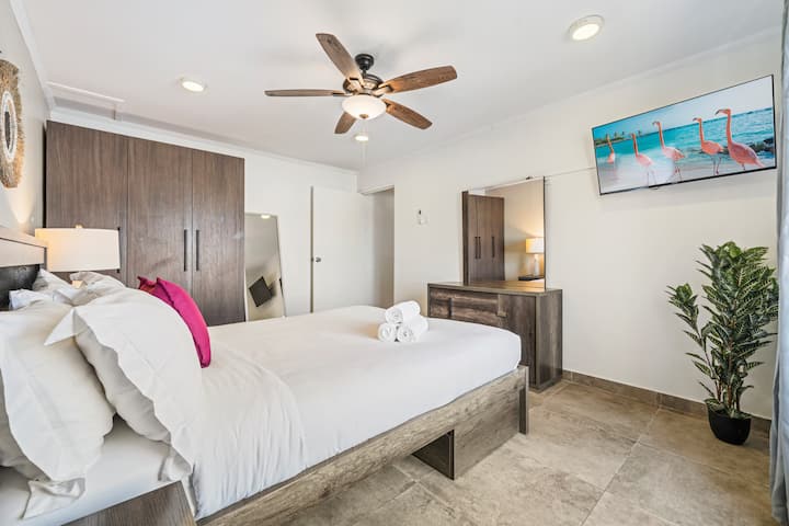 Relájate en tu dormitorio de Palm Beach con sábanas suaves y obras de arte de la isla