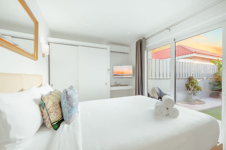 Quarto com ar-condicionado, TV e acesso direto ao pátio para manhãs frescas na ilha.