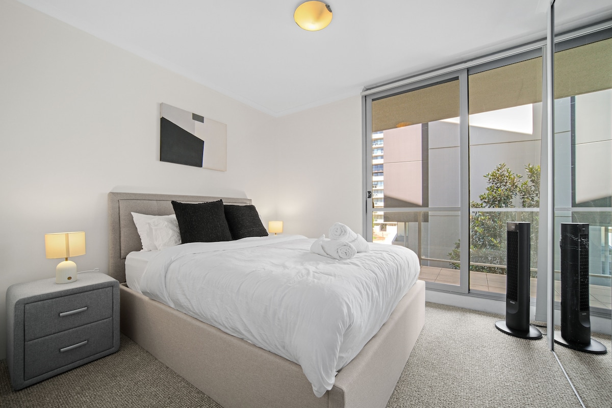 غرفة نوم مشرقة وجذابة بإضاءة دافئة وشرفة خاصة. استمتع بالفراش المريح والألوان الناعمة والهواء النقي على بعد خطوات قليلة من سريرك، وهو مثالي لقضاء ليلة هادئة أو قهوة صباحية هادئة.