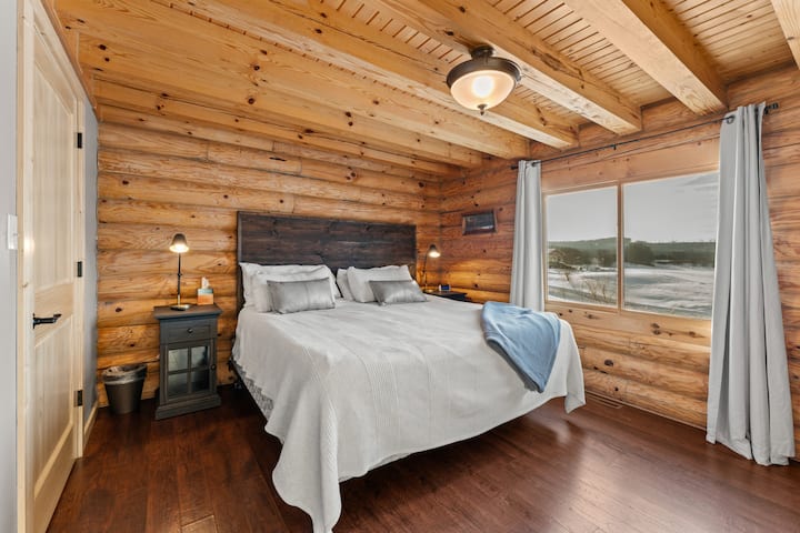 ️ Удобен главен апартман на главното ниво со брачен кревет (широк 180-220 см), рустикални дрвени ѕидови и големи прозорци со поглед на пејзажот. Внимателно дизајнирано за удобност и мирен сон.