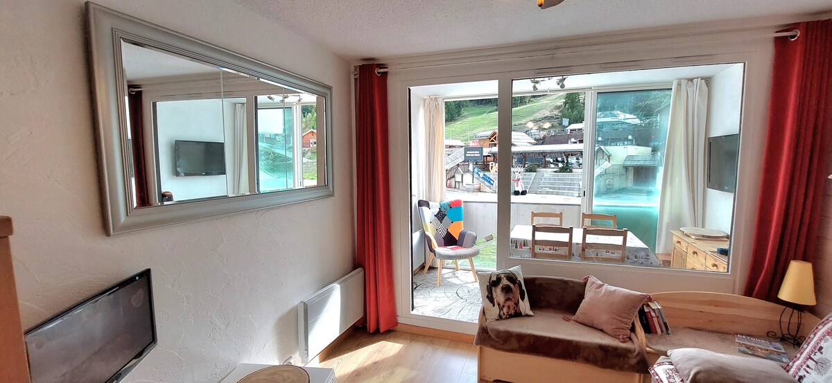 غرفة معيشة مشرقة وملونة تطل على شرفة تضم منطقة لتناول الطعام،
ستائر حرارية بيضاء على الشرفة،
وستائر حمراء معتمة في غرفة المعيشة للاستمتاع بالصباح المتأخر دون أن توقظك الشمس.