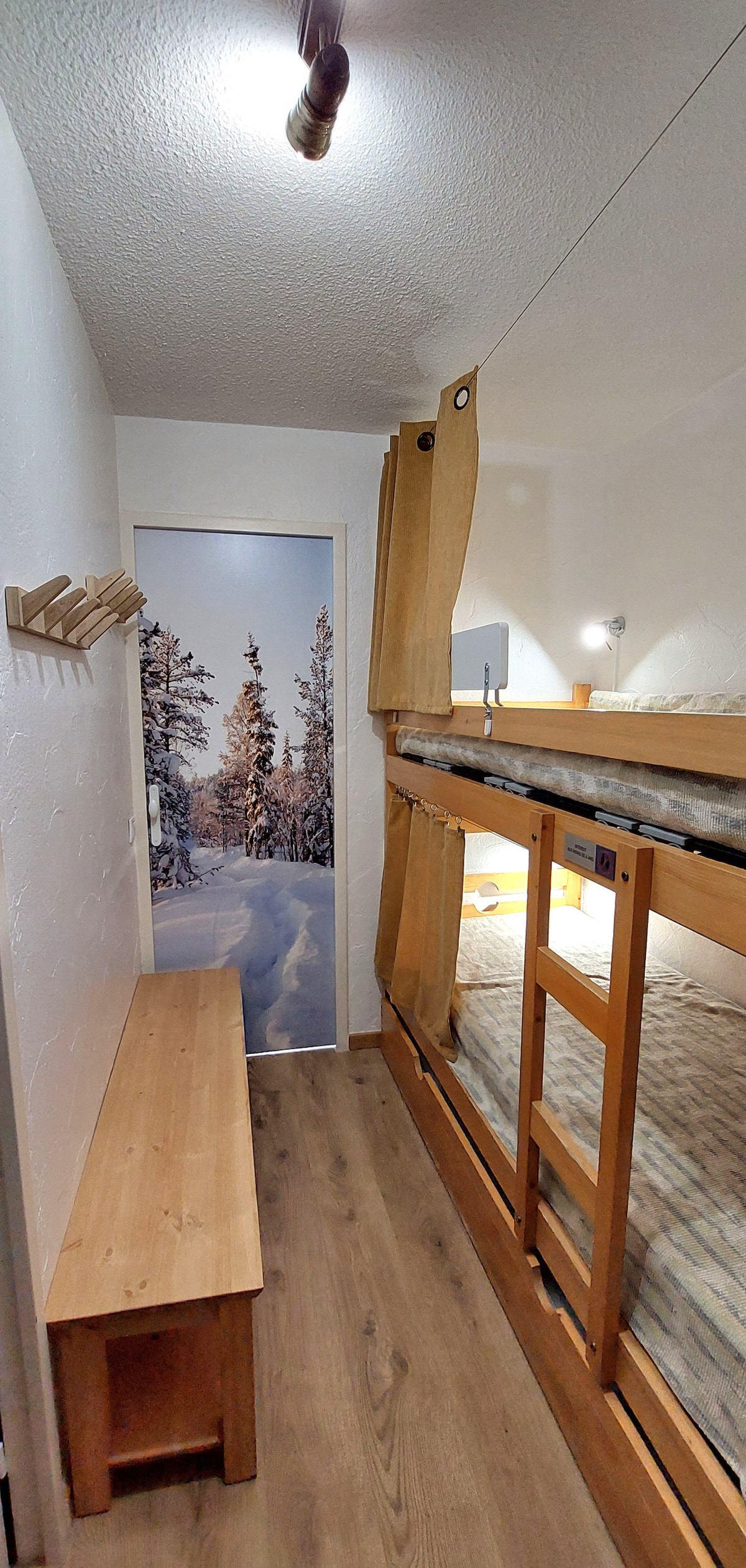 الزاوية الجبلية وسريريها بطابقين مع نقطة إضاءة وستارة مقصورة لمزيد من الخصوصية، 
ومقعد عملي كبير مع مساحة تخزين تحته،