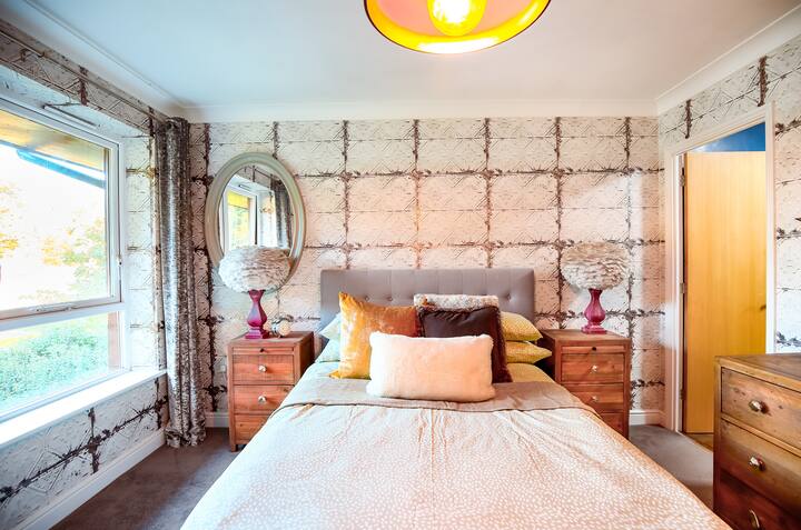 ห้องนอนสว่างพร้อมโต๊ะข้างเตียงและผ้าปูที่นอนใหม่